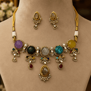 Gold-tone necklace set on bust with oval and round colored stones and dangling charms