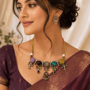 Statement necklace and matching earrings worn with maroon saree; gold-tone multi-stone design