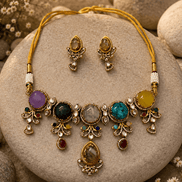 Gold-tone statement necklace and stud earrings with purple, blue, and black stones