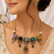 Gold-tone statement necklace and matching earrings close-up with colorful center stones