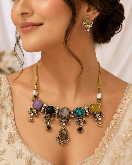 Gold-tone statement necklace and matching earrings close-up with colorful center stones