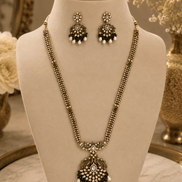Gold-tone necklace set with emerald-green beaded pendant and matching drop stud earrings