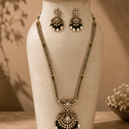 Gold-tone necklace set with emerald-green beaded teardrop pendant and stud earrings