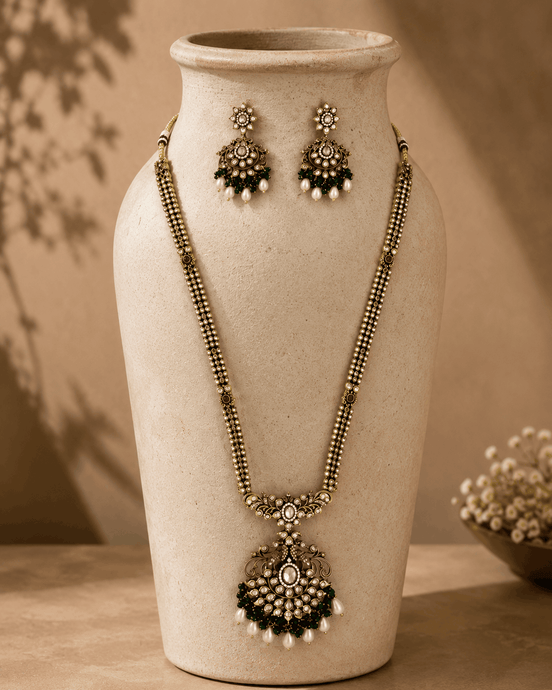 Gold-tone necklace set with emerald-green beaded teardrop pendant and stud earrings