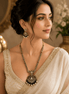 Gold-tone necklace set with emerald-green beaded pendant and matching drop earrings