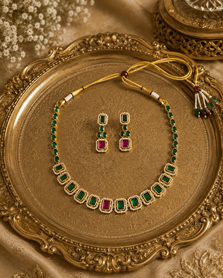 Gold-tone necklace with green stones and red accents with matching stud earrings