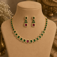 Gold-tone necklace with green stones and pink-red accents with matching stud earrings