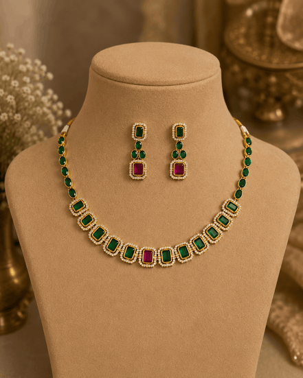 Gold-tone necklace with green stones and pink-red accents with matching stud earrings