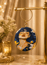 Round blue illustrated clutch bag with gold-tone chain and dangling portrait charm