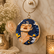 Round blue illustrated clutch bag with gold-tone chain, portrait front and hook clasp