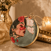 Round maroon illustrated clutch bag with gold-tone chain and profile floral portrait