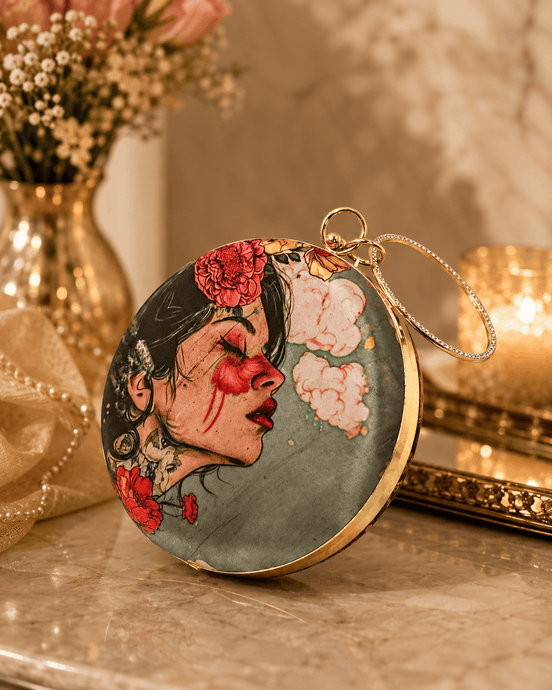 Round maroon illustrated clutch bag with gold-tone chain and profile floral portrait