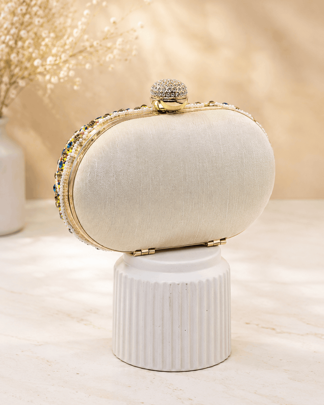 Cream fabric clutch with multicolor beaded edge and gold-tone top clasp