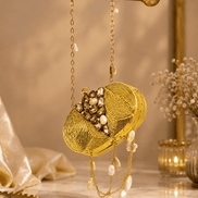 Gold beaded round clutch with textured swirl pattern and pearl drop fringe on chain