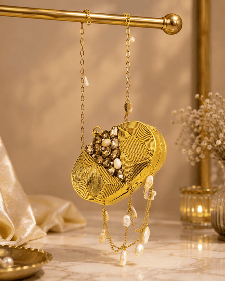 Gold beaded round clutch with textured swirl pattern and pearl drop fringe on chain