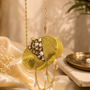Gold round clutch with crystal beading, textured front, and dangling pearl chain