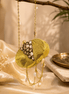 Gold round clutch with crystal beading, textured front, and dangling pearl chain