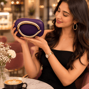 Purple sculptural handle clutch bag with gold-toned frame clasp.