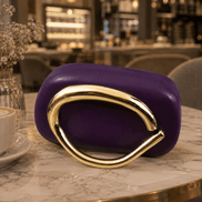Purple clutch with curved gold-toned handle and glossy front.