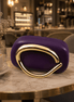 Purple clutch with curved gold-toned handle and glossy front.