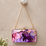 Alora clutch with gold chain strap and clasp, pink and purple marble pattern.