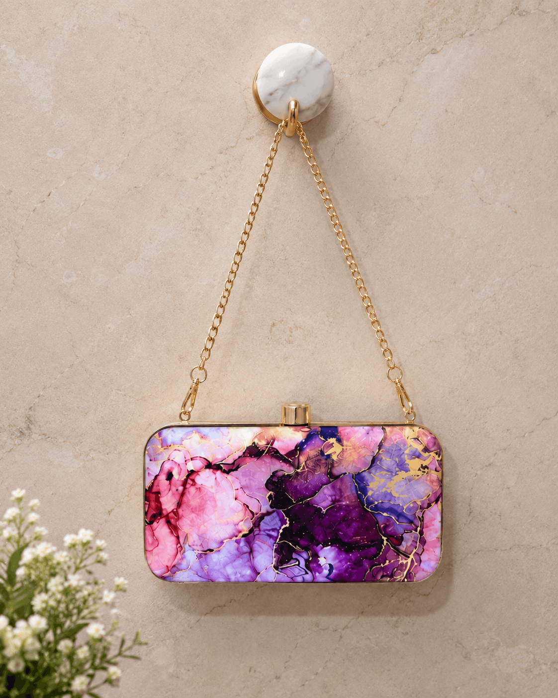 Alora clutch with gold chain strap and clasp, pink and purple marble pattern.
