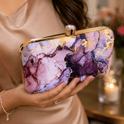 Alora clutch close-up with gold-tone frame and clasp, purple and pink marble print.