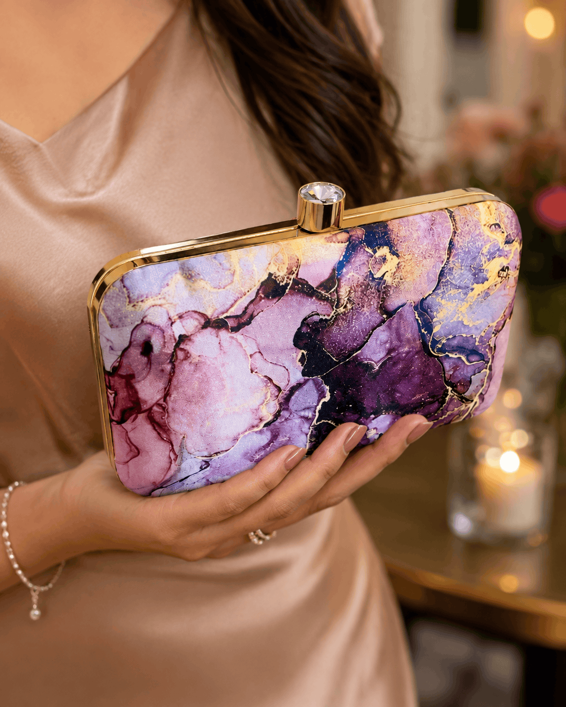 Alora clutch close-up with gold-tone frame and clasp, purple and pink marble print.