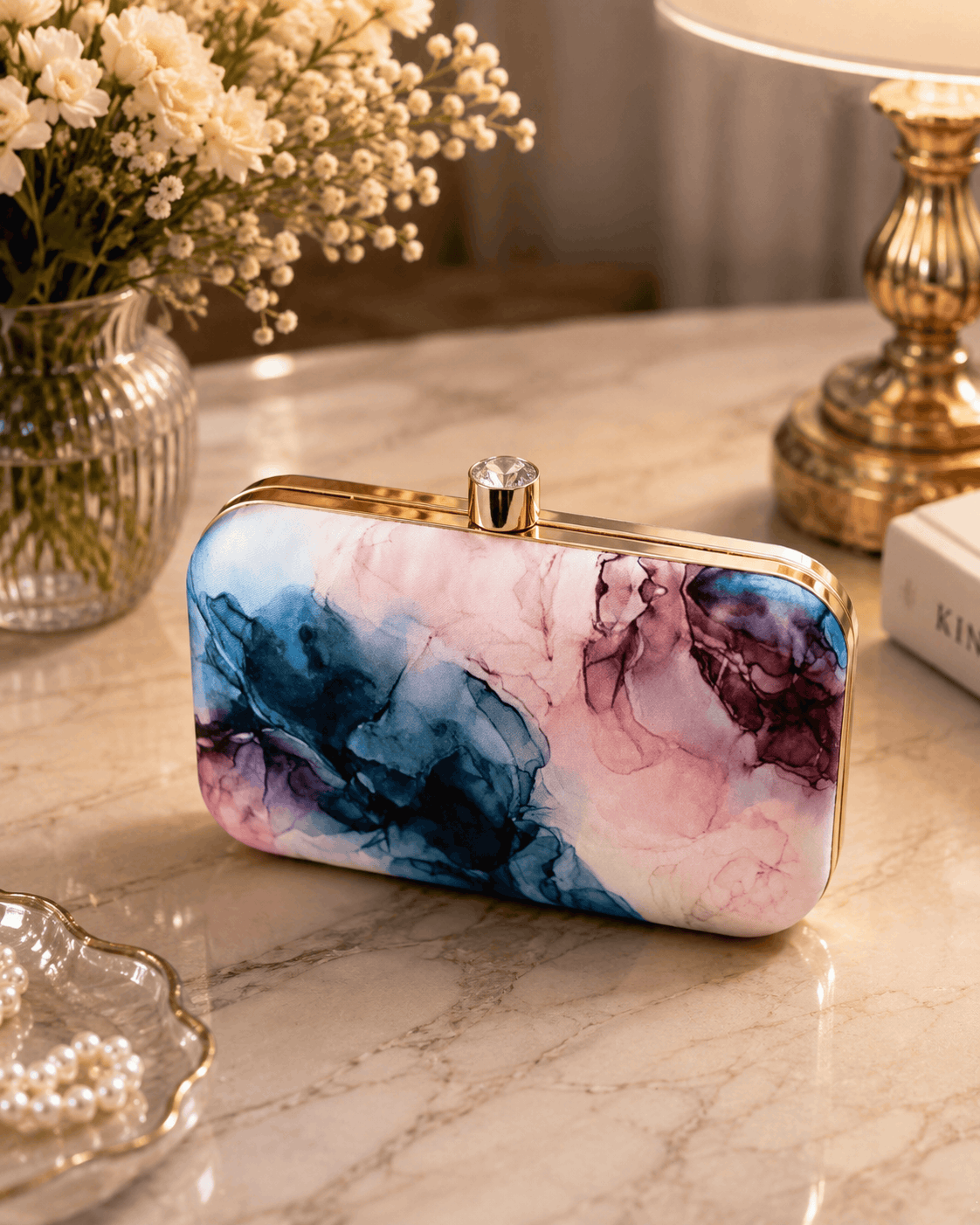 Alora Clutch with marbled blue and pink pattern, gold-tone clasp and frame.