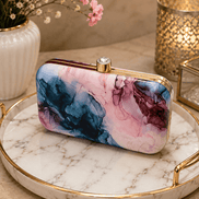 Alora clutch with gold-tone frame and clasp, pink and blue marble print.