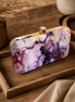 Alora clutch with gold-tone frame and clasp, plum purple and pink marble print.