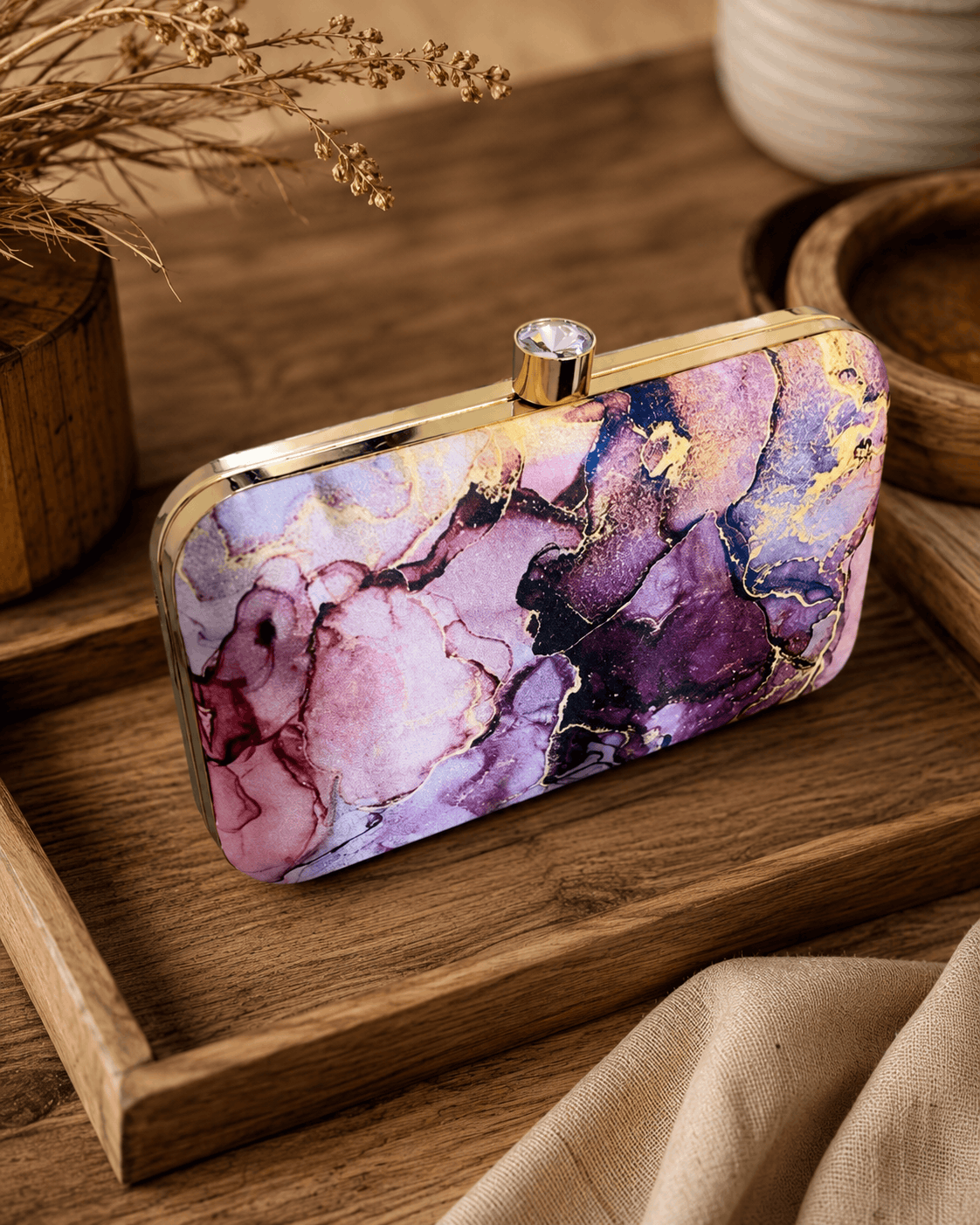 Alora clutch with gold-tone frame and clasp, plum purple and pink marble print.