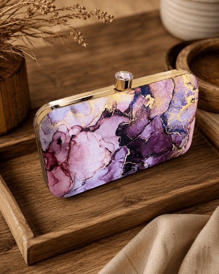 Alora clutch with gold-tone frame and clasp, plum purple and pink marble print.