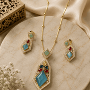 Gold-tone pendant necklace set with teal and red gemstone drop earrings