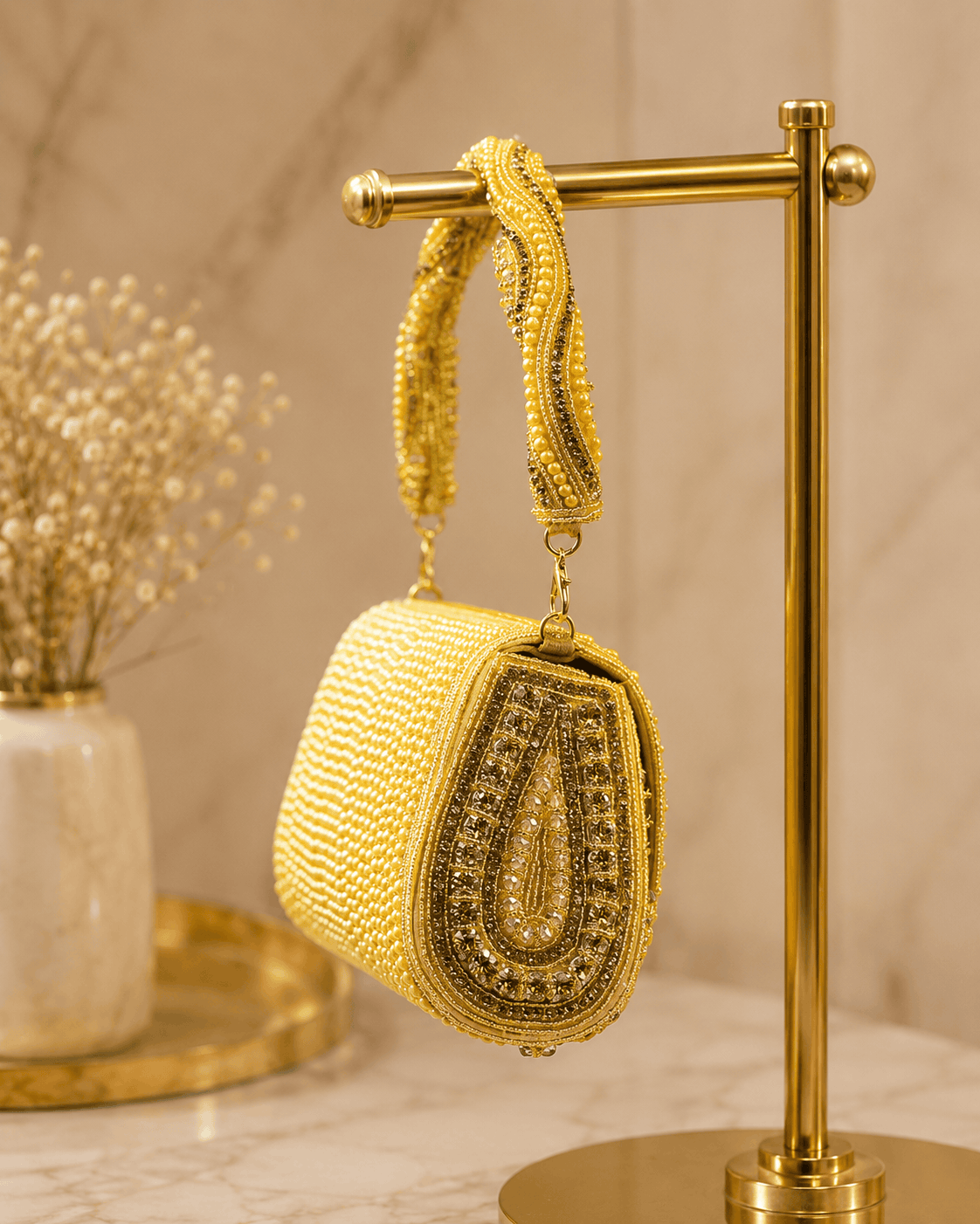 Gold beaded shoulder bag hanging on display stand, arched front with beadwork