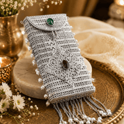 Silver filigree mobile clutch close-up with oval green and purple gems and pearl tassels