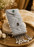 Silver filigree mobile clutch close-up with oval green and purple gems and pearl tassels
