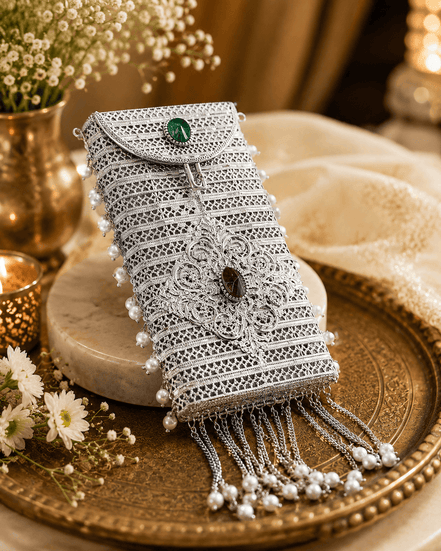 Silver filigree mobile clutch close-up with oval green and purple gems and pearl tassels