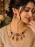 Gold-tone kundan necklace with multicolor stone drops and matching earrings on model