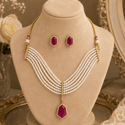 Gold-tone multi-strand pearl necklace with maroon drop pendant and stud earrings