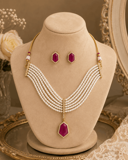 Gold-tone multi-strand pearl necklace with maroon drop pendant and stud earrings