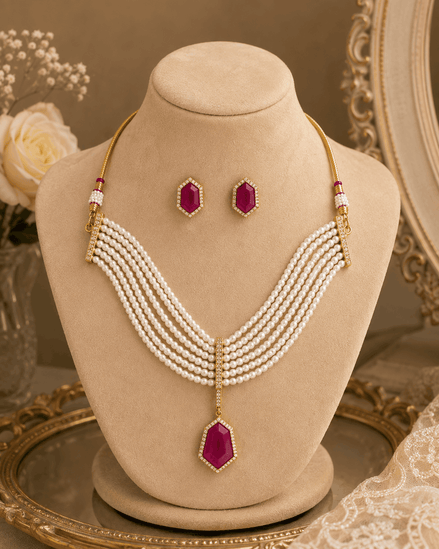 Gold-tone multi-strand pearl necklace with maroon drop pendant and stud earrings