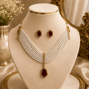 Gold-tone pearl necklace set with maroon drop pendant and matching stud earrings