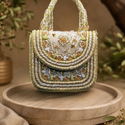Beige beaded shoulder bag, front view with stacked bead panels and decorative stones