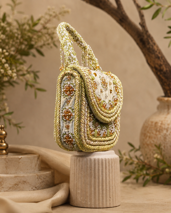 Beige beaded shoulder bag with arched top handle and layered bead trim