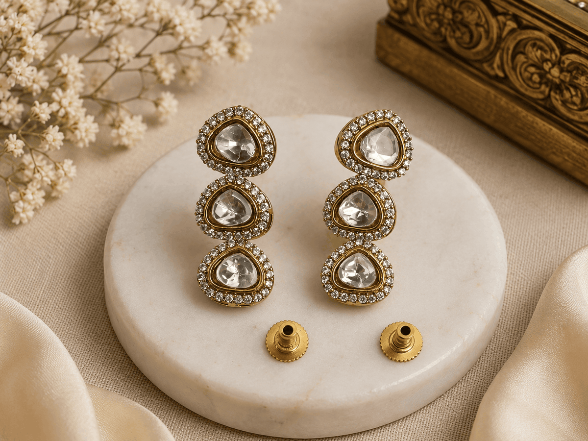 Gold-tone triple drop earrings with three round crystal stones and post backs