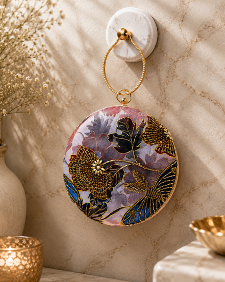 Multicolor embroidered circular ring clutch with gold-toned ring handle and front floral design.