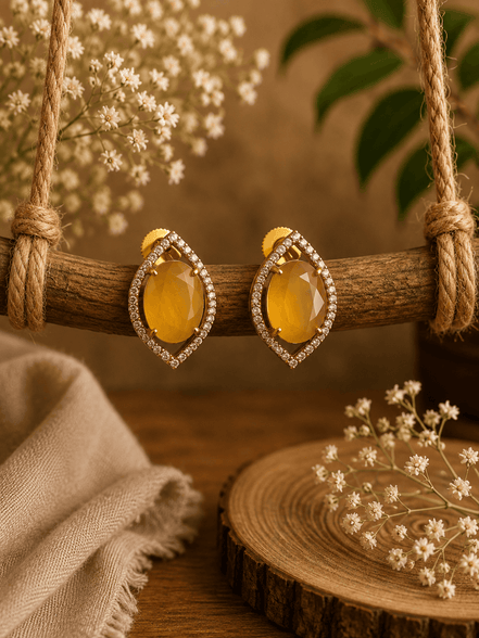 Yellow teardrop halo stud earrings with pave crystal border, gold-tone setting.