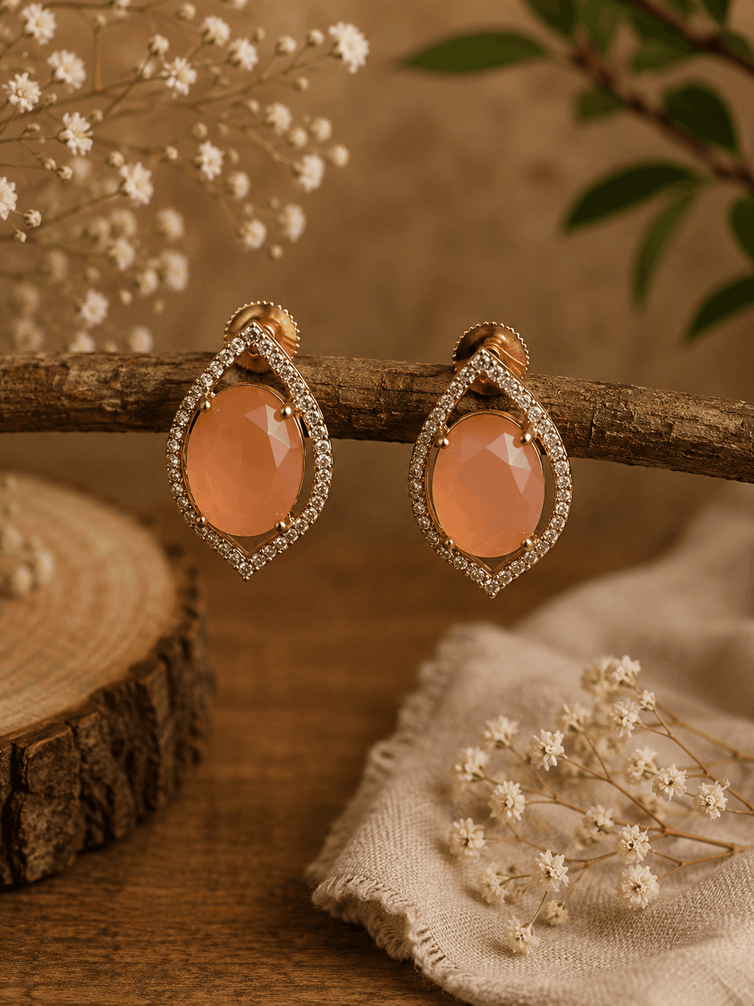 Peach teardrop halo stud earrings with pavé crystal border, gold-tone setting.