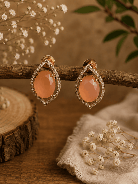 Peach teardrop halo stud earrings with pavé crystal border, gold-tone setting.
